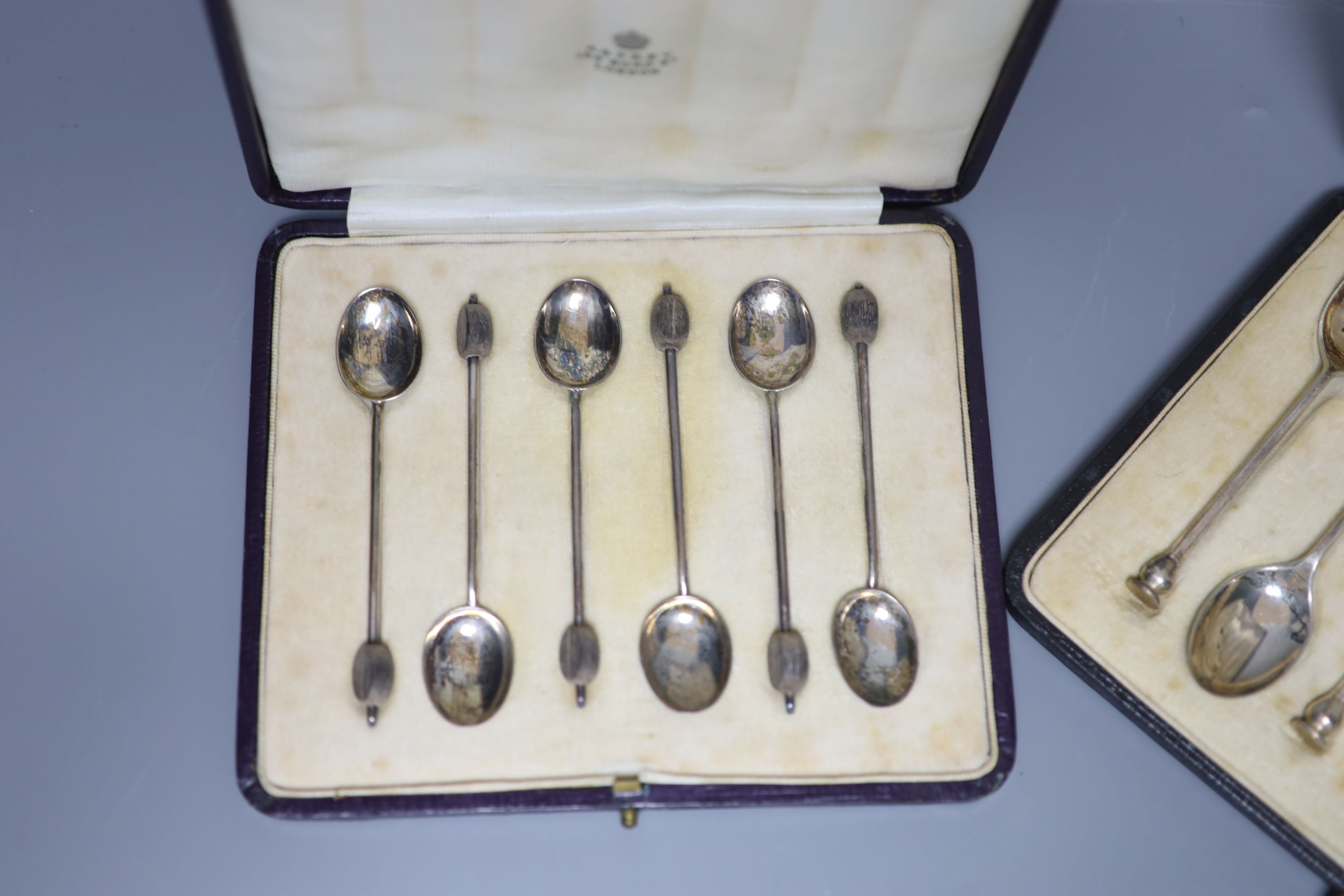 A cased set of six seal top teaspoons and tongs and a cased set of silver silver bean end coffee spoons.